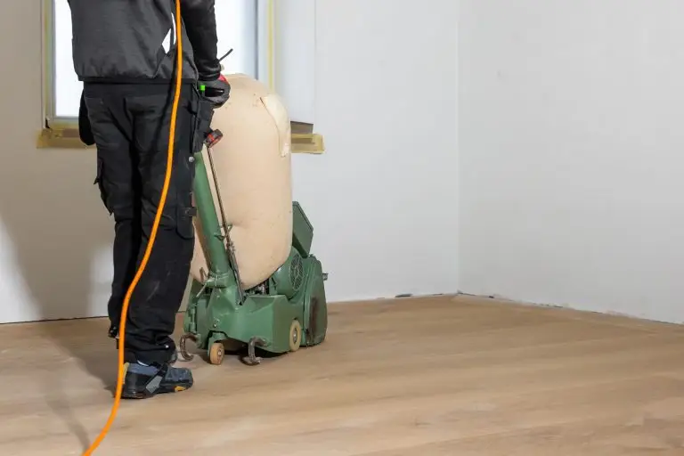 worker operates green floor polishing machine