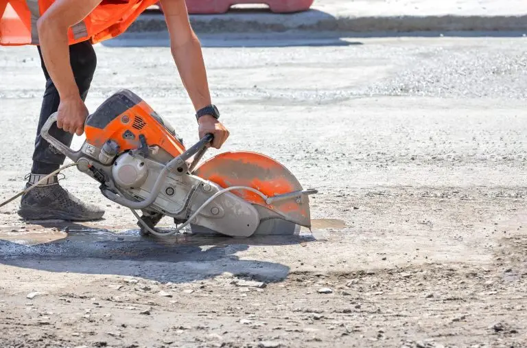 worker using electric concrete hand saw